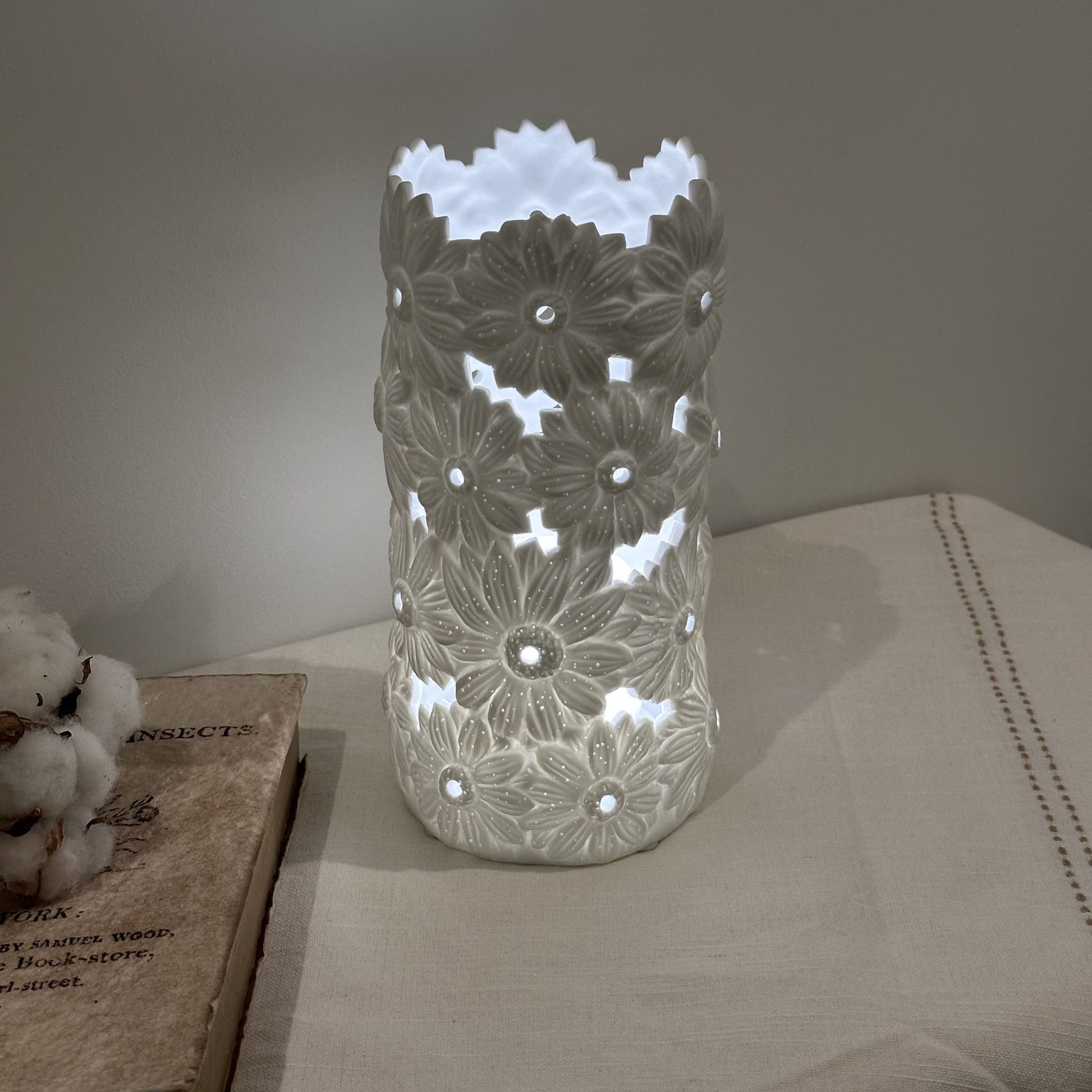 A porcelain lamp with 3D effect daisy flower design lit up