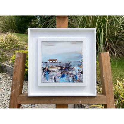A ceramic tile printed with an abstract painting of a cottage and daisy flowers mounted on a white frame
