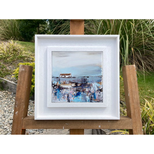 A ceramic tile printed with an abstract painting of a cottage and daisy flowers mounted on a white frame