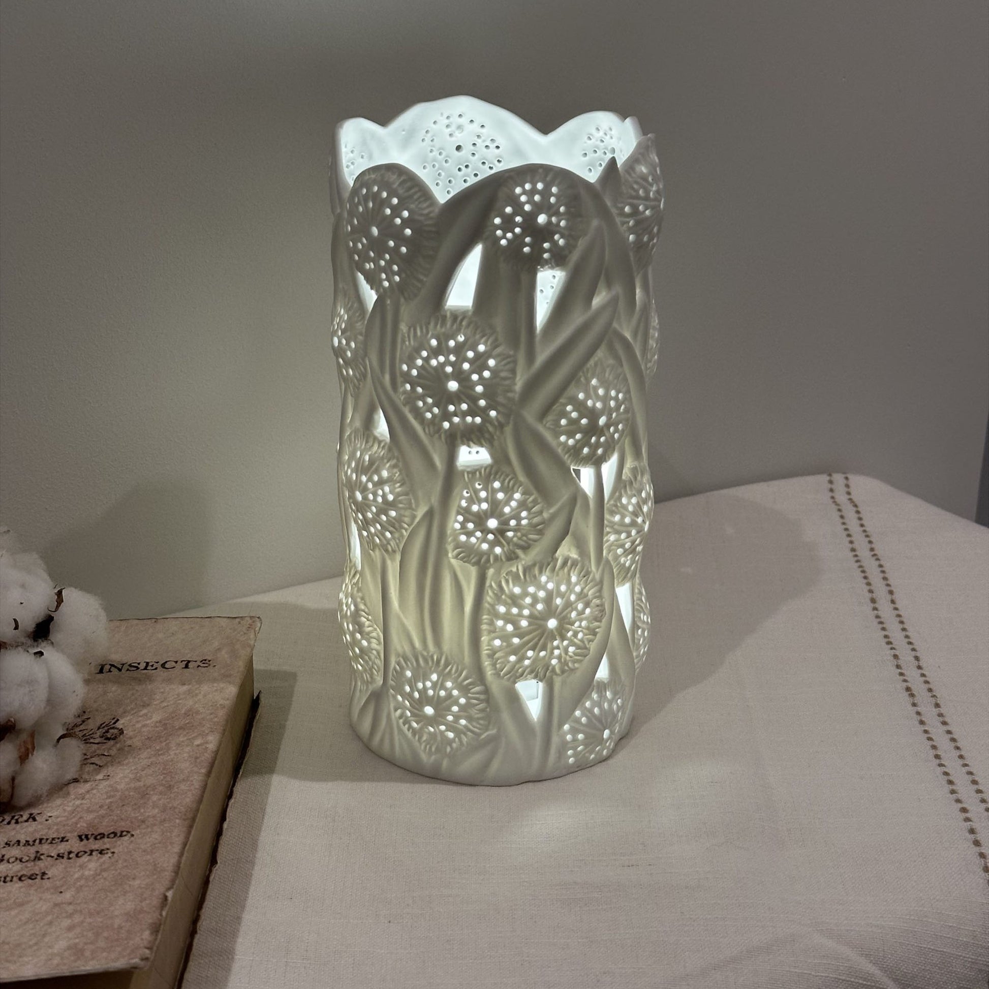 A porcelain lamp with 3D effect dandelion puff design lit up