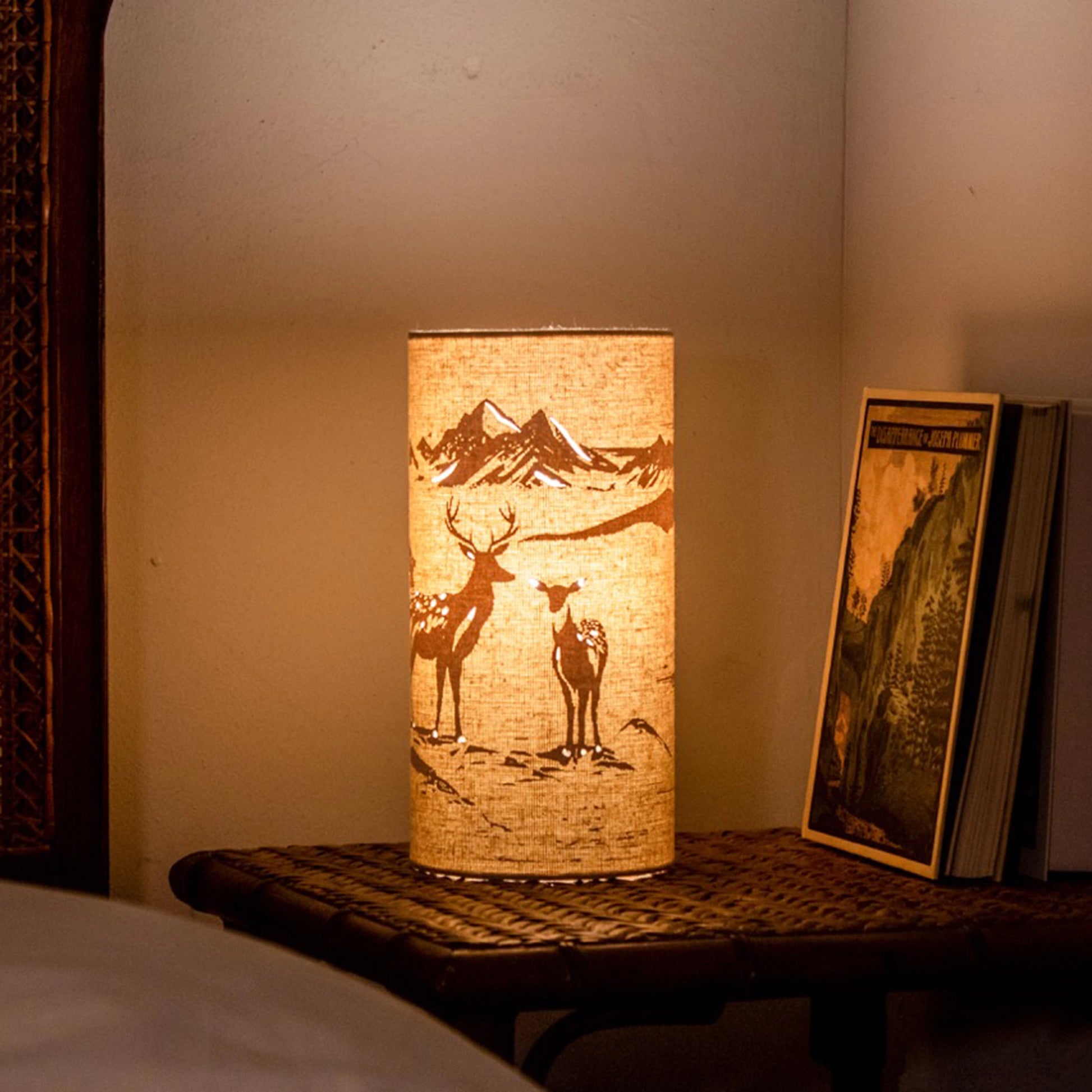 A linen look fabric table lamp with a love deer design and cut out details lifestyle