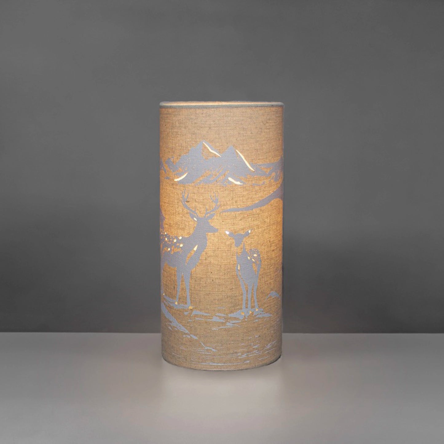 A linen look fabric table lamp with a love deer design and cut out details on