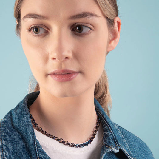 Model wearing a chain linked titanium necklace in denim blue and copper