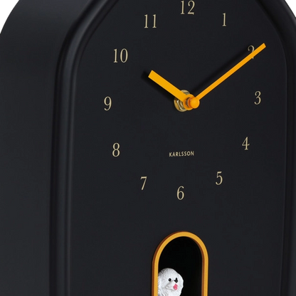 Black wall clock with yellow gold details, Arabic numerals  and white dog cuckoo 