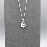 A double twisted teardrop shaped pendant with matt silver