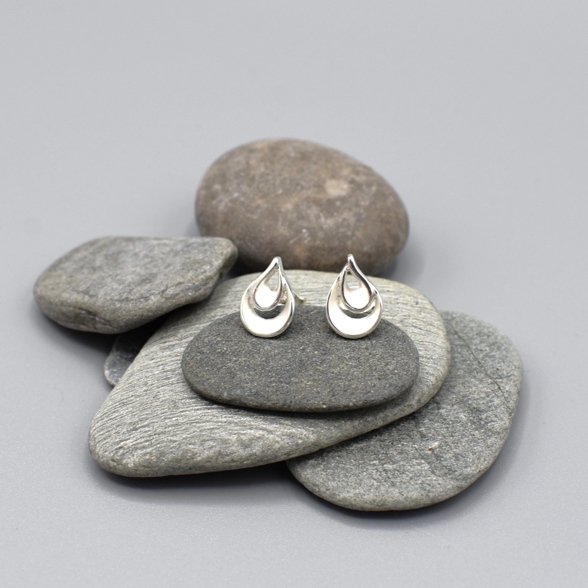 A pair of twisted double teardrop shaped stud earrings in matt silver