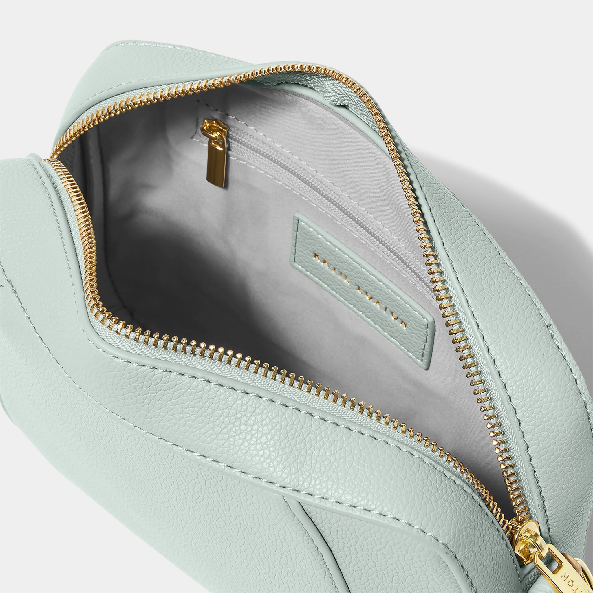 Open light blue crossbody bag in a simple box shape with adjustable strap and gold hardware