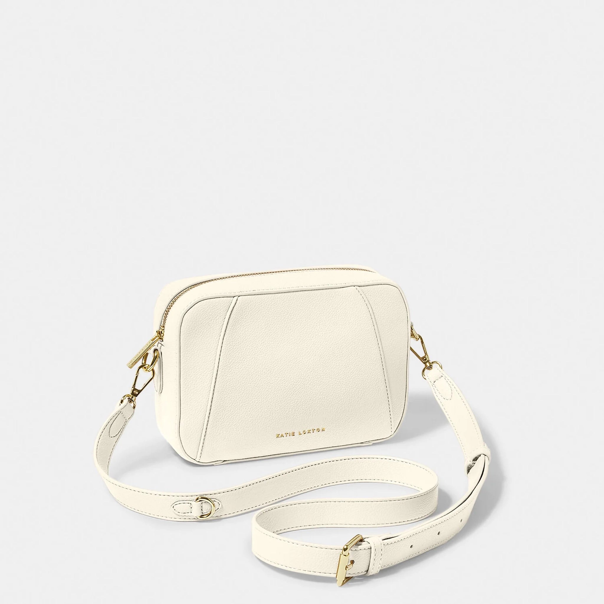 A ecru crossbody bag in a simple box shape with adjustable strap and gold hardware