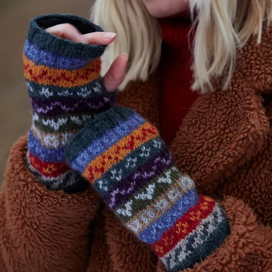 Model wearing a pair of knitted handwarmers with a Fair Isle pattern in neutral tones