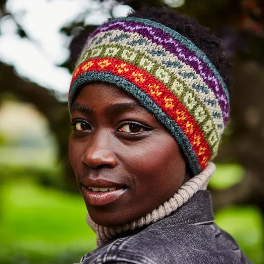 Model wearing a knitted headband in earthy toned stripes and fair isle style pattern