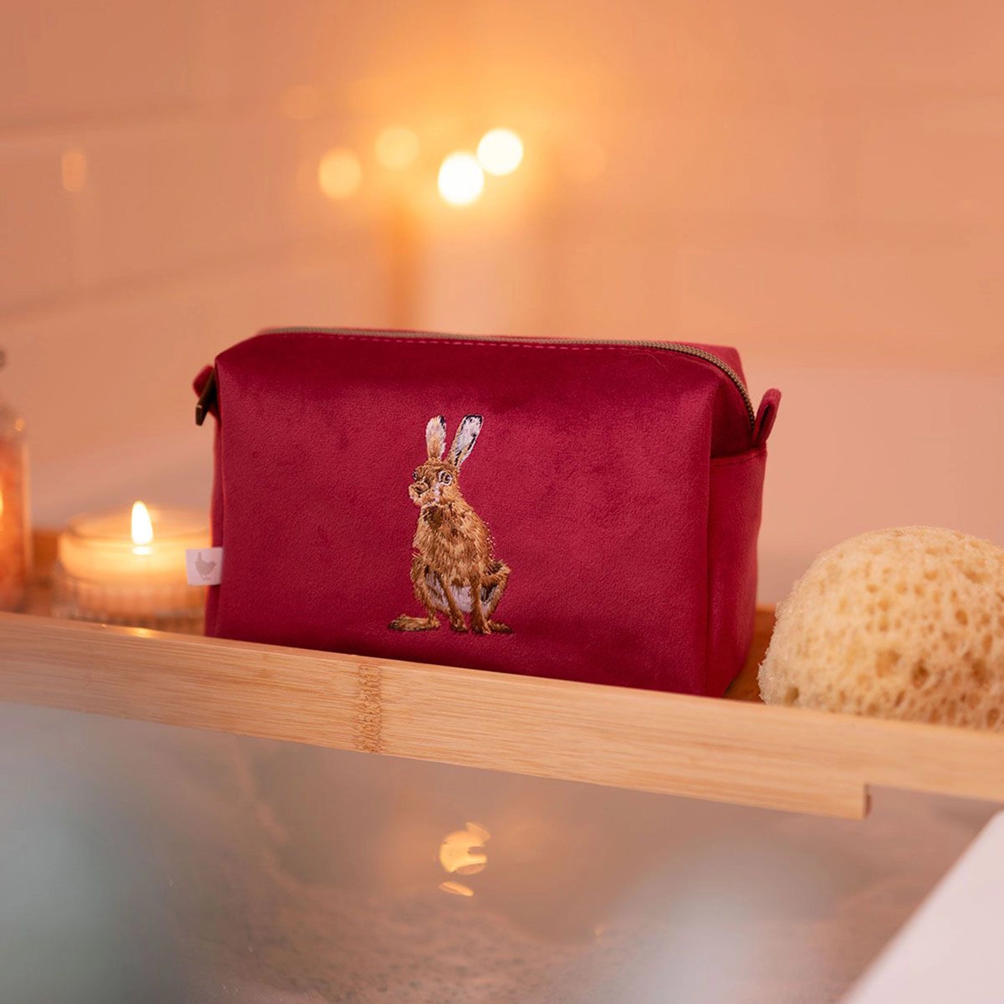 Red make up bag with embroidered hare design and zip top lifestyle