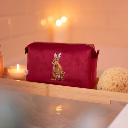 Red make up bag with embroidered hare design and zip top lifestyle