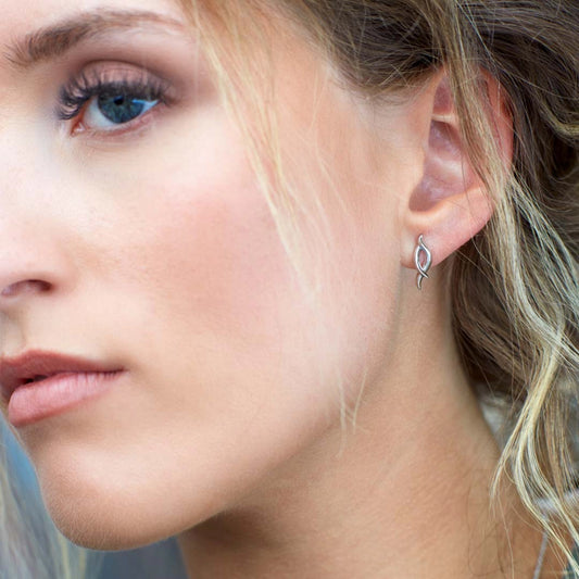Model wearing a pair of silver elongated twist marquise shaped stud earrings