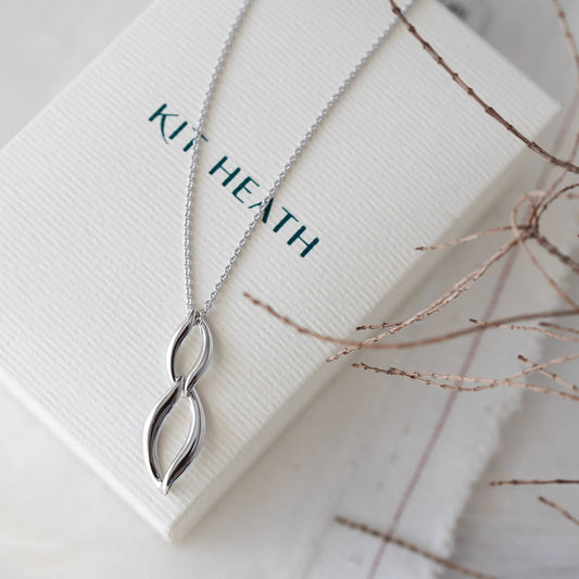 A pendant featuring linked marquis twists in silver on Kit Heath box