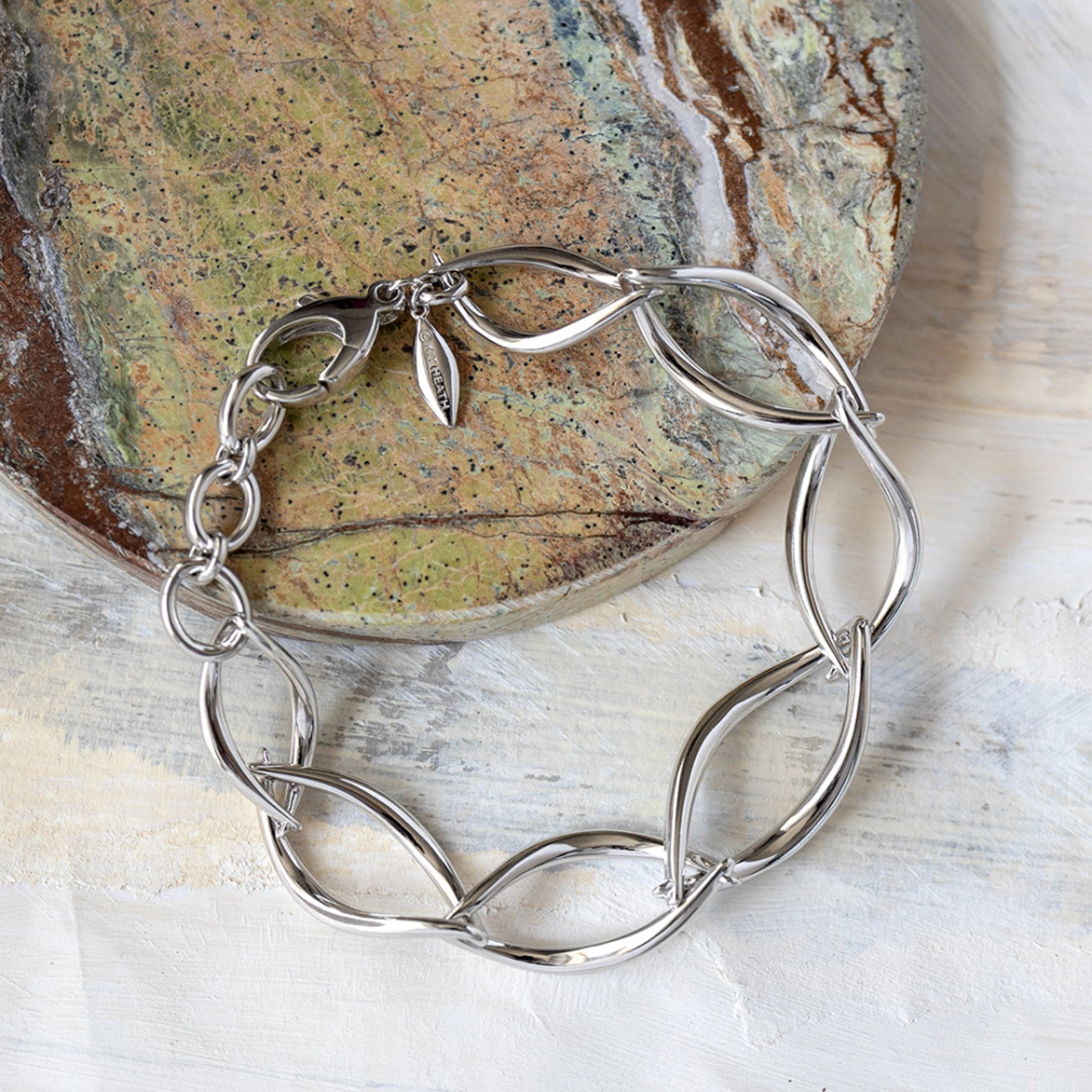 A bracelet of silver links in a simple twist marquise shapes lifestyle image