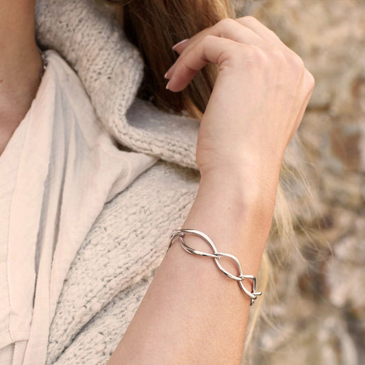 Model wearing a bracelet of silver links in a simple twist marquise shapes 