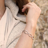 Model wearing a bracelet of silver links in a simple twist marquise shapes 