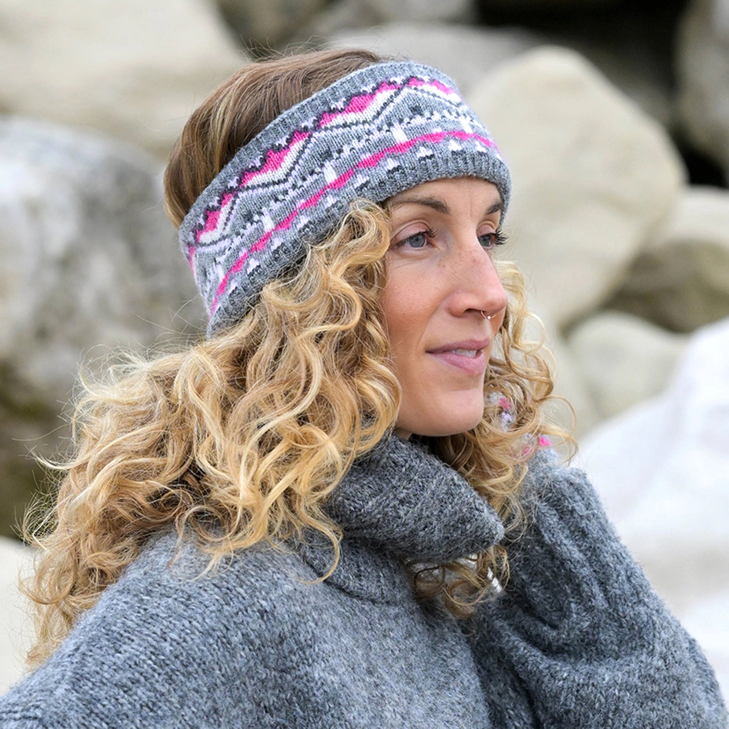 Model wearing knitted fair isle patterned headband in grey and pink