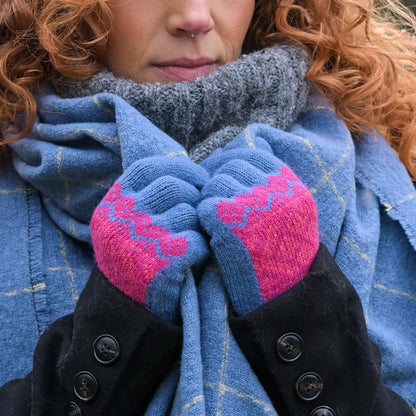 Model wearing blue knitted gloves with a red/pink fair isle style pattern