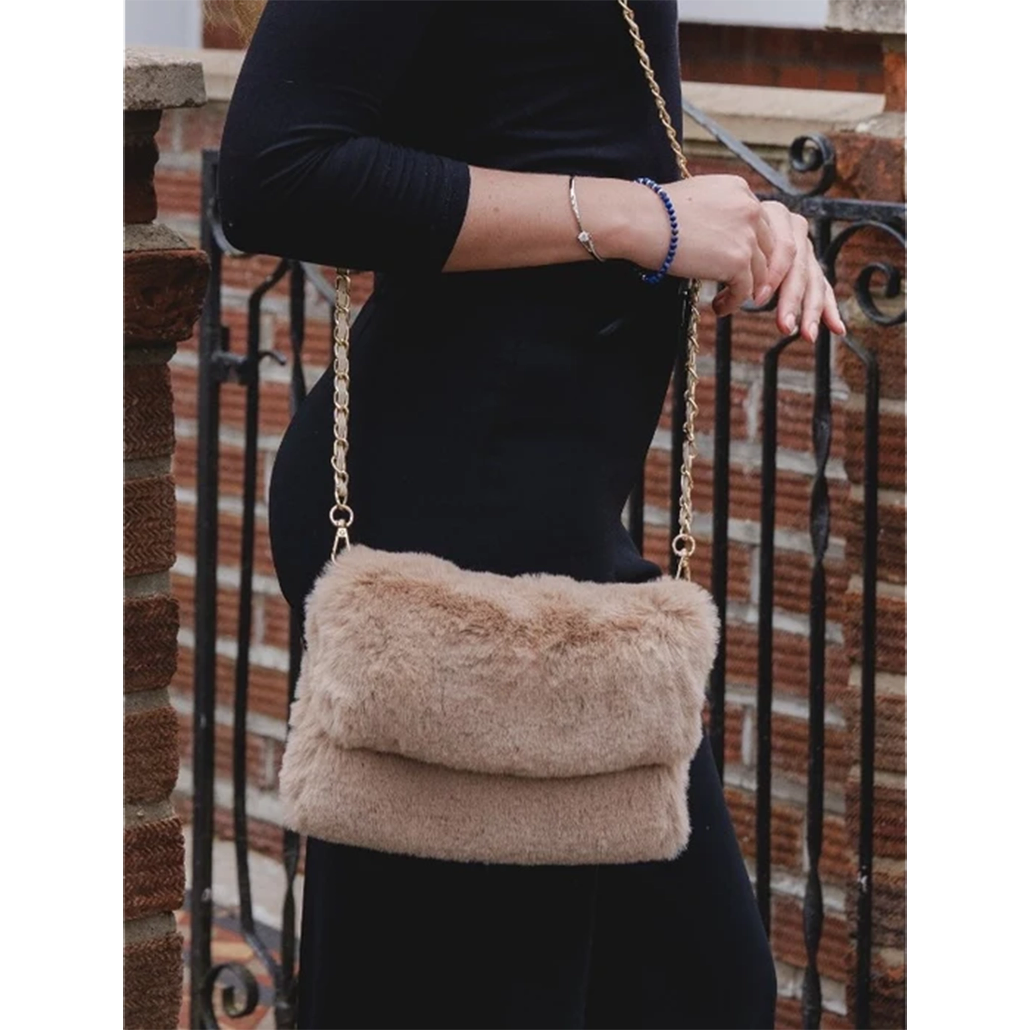 Model with a faux fur bag in cappuccino brown with gold chain shoulder strap