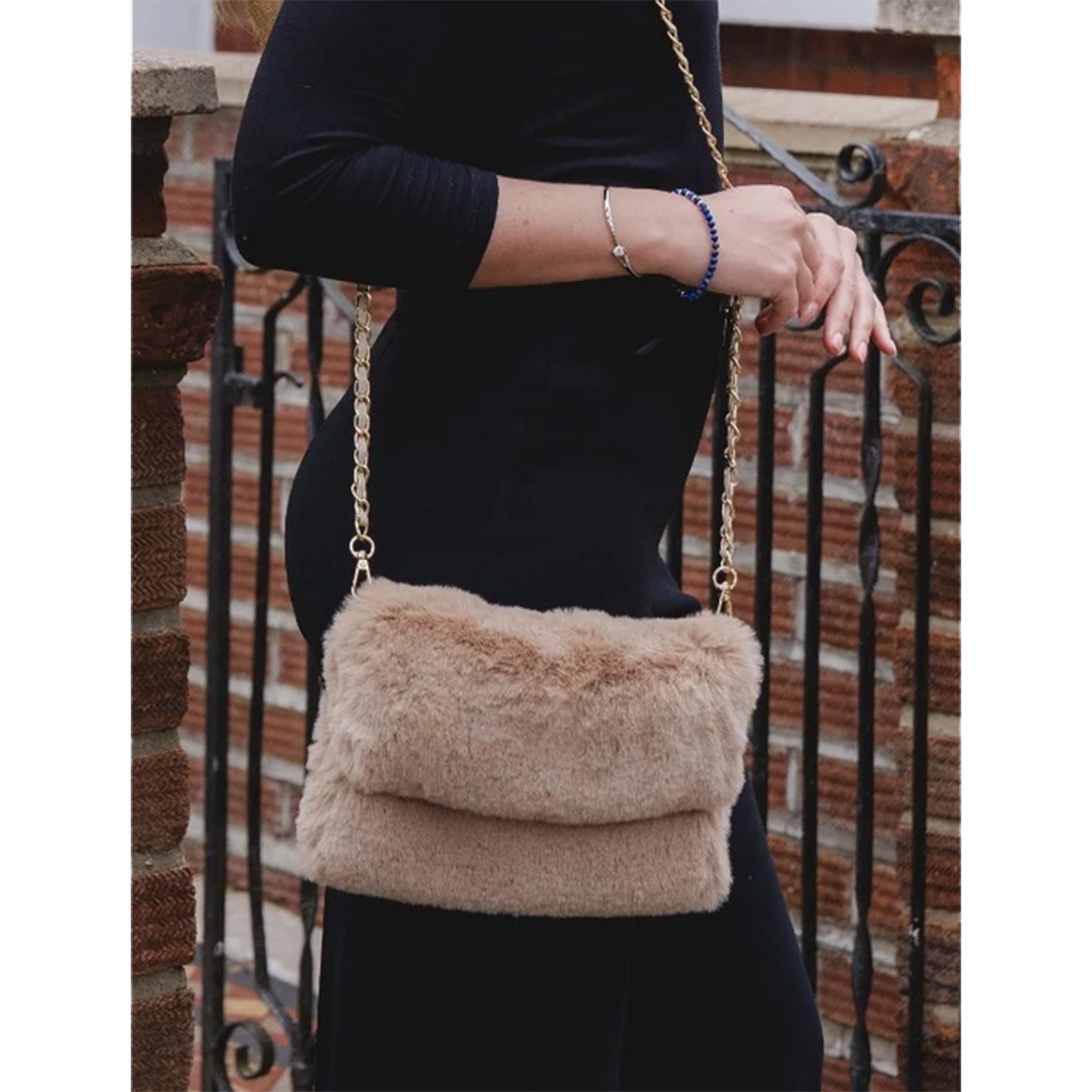 Model with a faux fur bag in cappuccino brown with gold chain shoulder strap