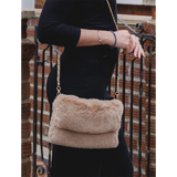 Model with a faux fur bag in cappuccino brown with gold chain shoulder strap