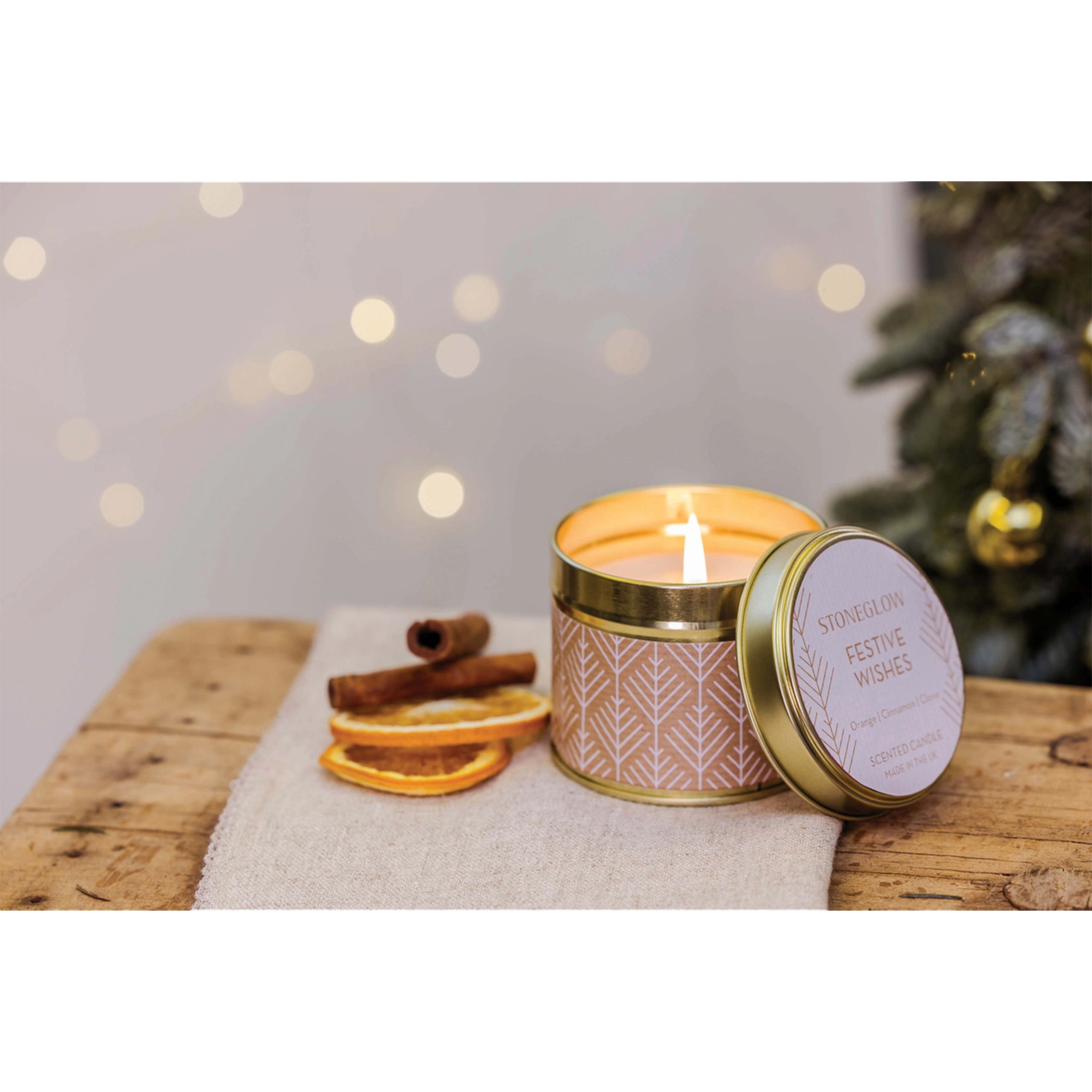 A gold tine candle with scandi style white pattern on brown paper in the scene 'Festive Wishes' - Lifestyle