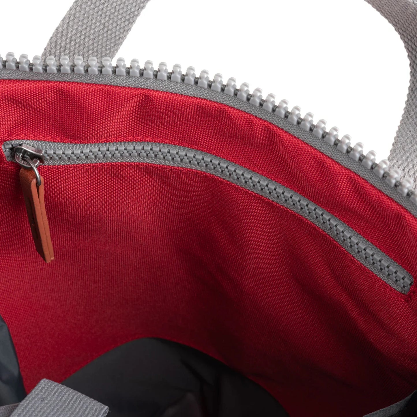 Red rolltop backpack with grey interior zip pocket