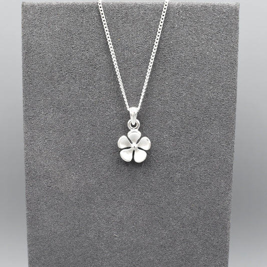 A matt textured silver flower pendant on silver chain