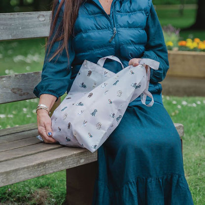 Model wearing grey shopping tote bag with dog pattern