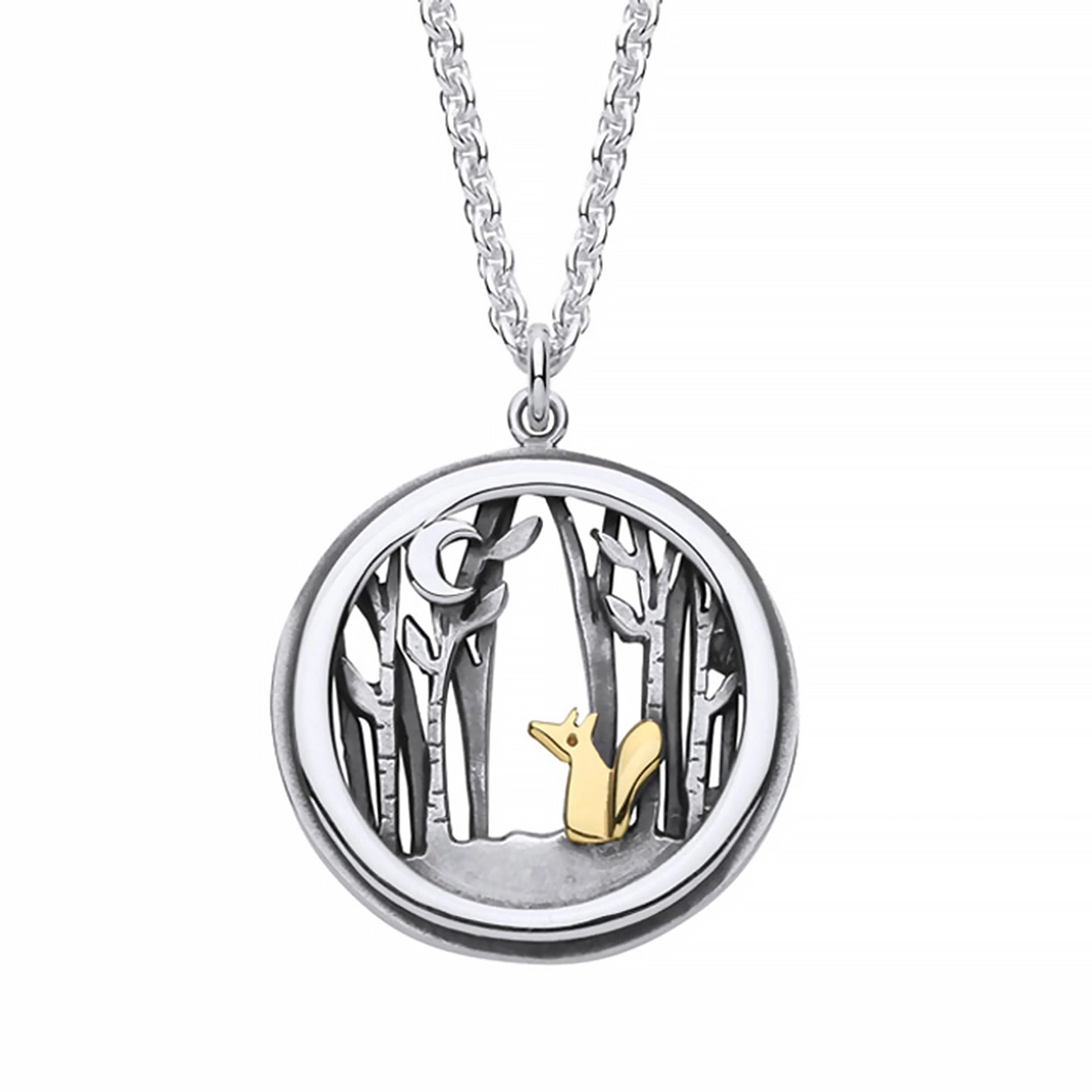 A round pendant with gold fox in a silver forest under a crescent moon