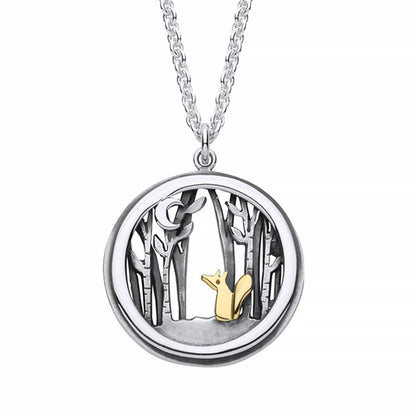 A round pendant with gold fox in a silver forest under a crescent moon