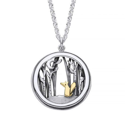 A round pendant with gold fox in a silver forest under a crescent moon