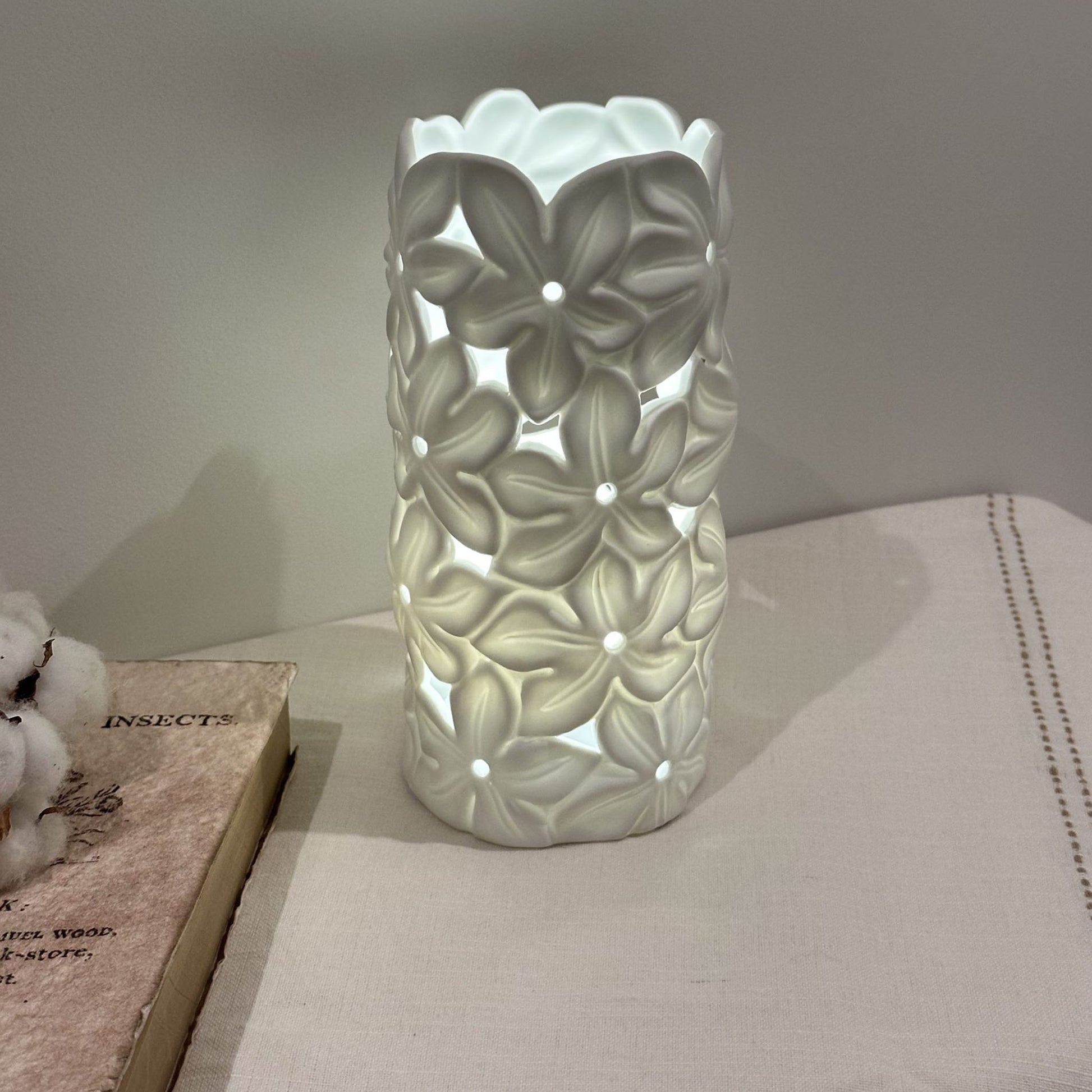 A porcelain lamp with 3D effect tropical frangipani flower design on