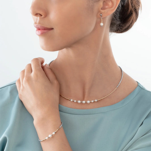 Model wearing a jewellery set in silver and gold with round freshwater pearls