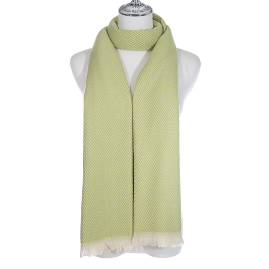 A light green scarf with chevron pattern and short white fringe