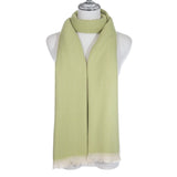 A light green scarf with chevron pattern and short white fringe