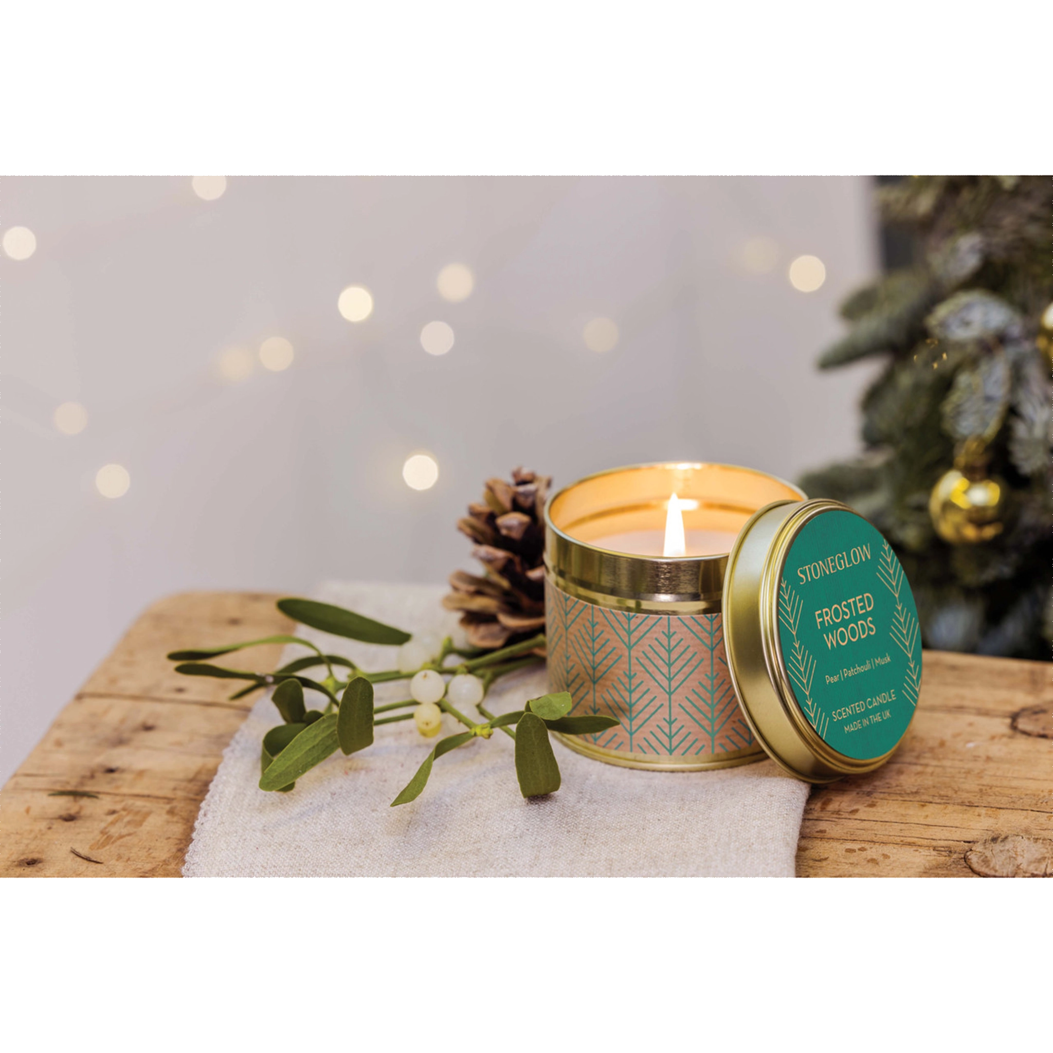 A gold tine candle with scandi style green pattern on brown paper in the scene 'Festive Wishes' - Lifestyle