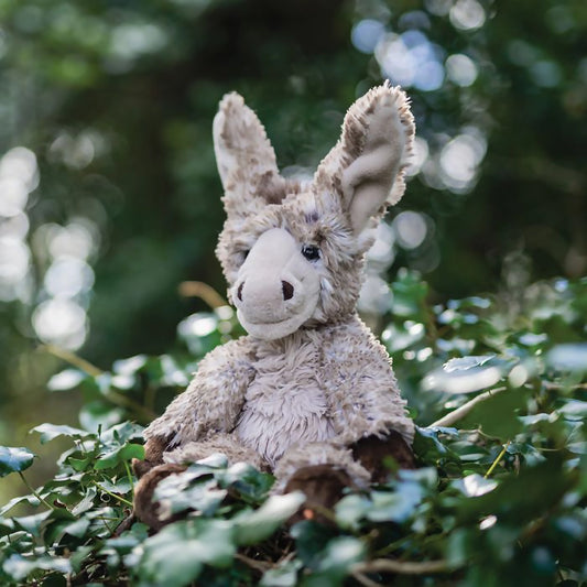 Stuffed donkey plush toy posed in ivy