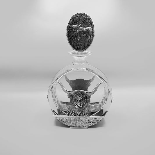 A glass decanter with pewter Highland cow oval stopper and Highland cow  design on the base