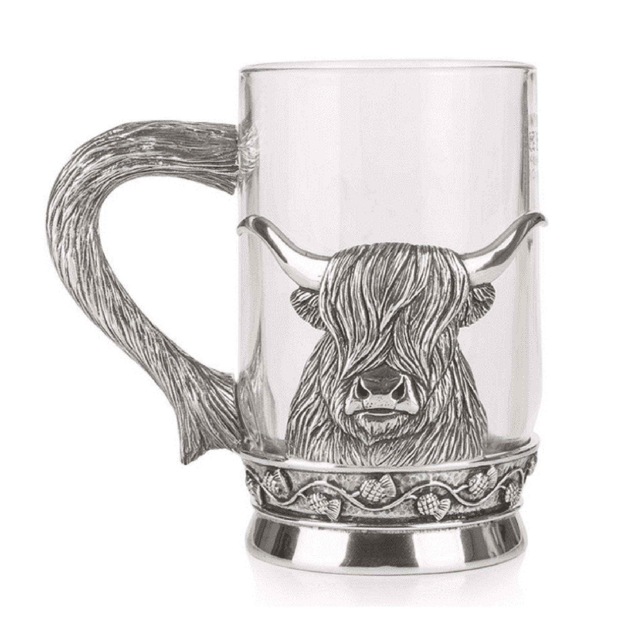 A glass tankard with a pewter Highland cow and horn shaped handle