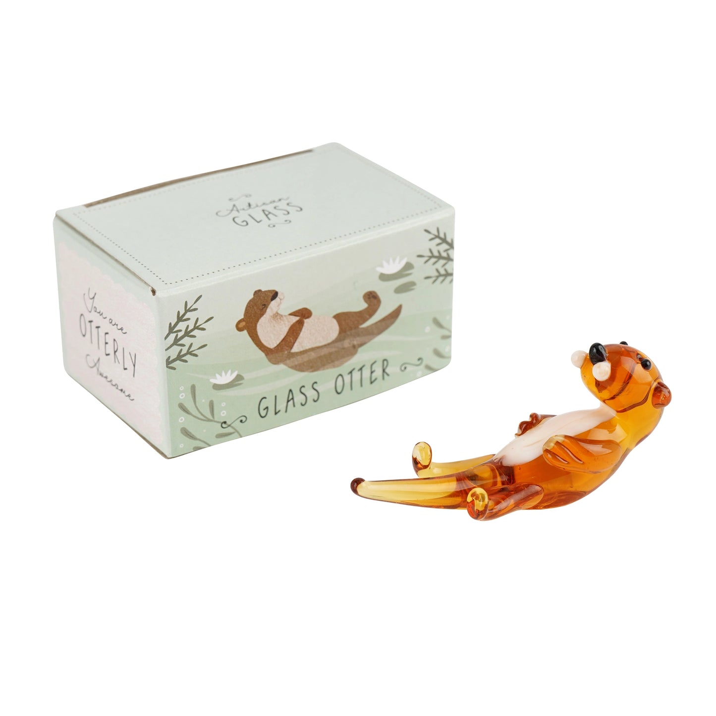 Glass otter figurine swimming on its back next to a matching gift box