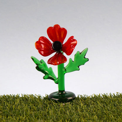 Glass red poppy figurine on faux grass