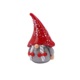 Small glass ornament of a gonk with braids, a red speckled hat and a grey dress turned left