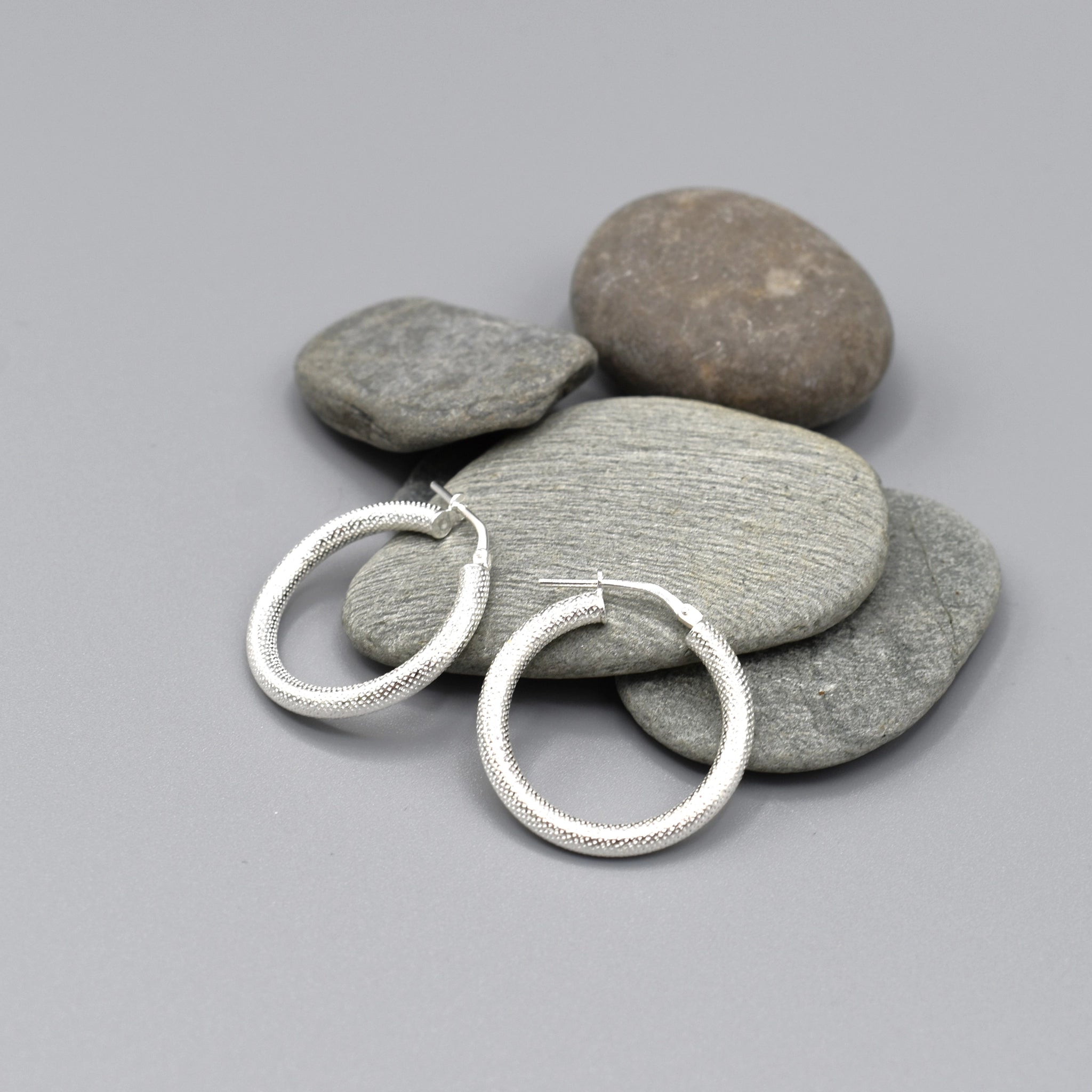 A pair of textured round silver hoop earrings