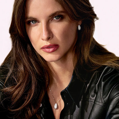 Model wearing curved teardrop pendant with silver chain and CZ stones