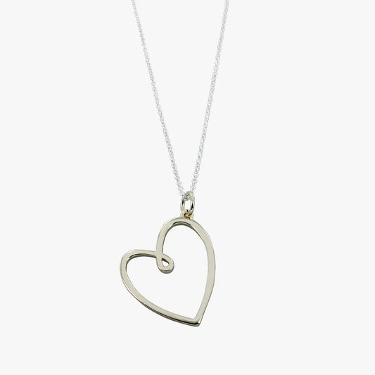 A gold pendant on a silver chain in an open frame looped heart shape