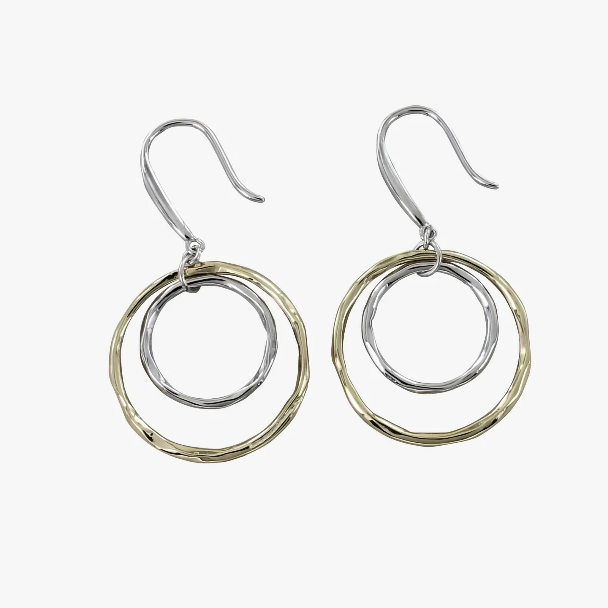 A pair of drop earrings featuring a small silver hoop inside a larger gold one with irregular texturing