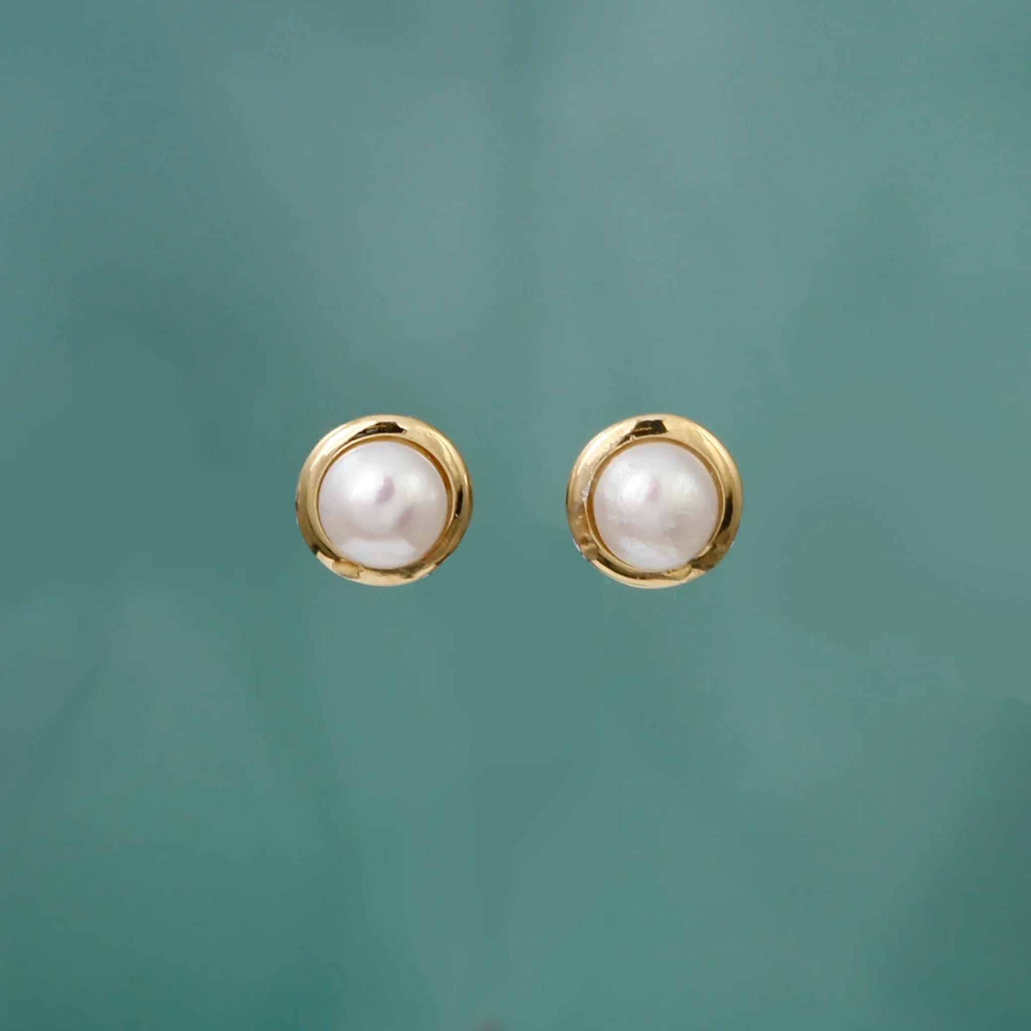 A round pair of stud earrings with 14k gold vermeil frames