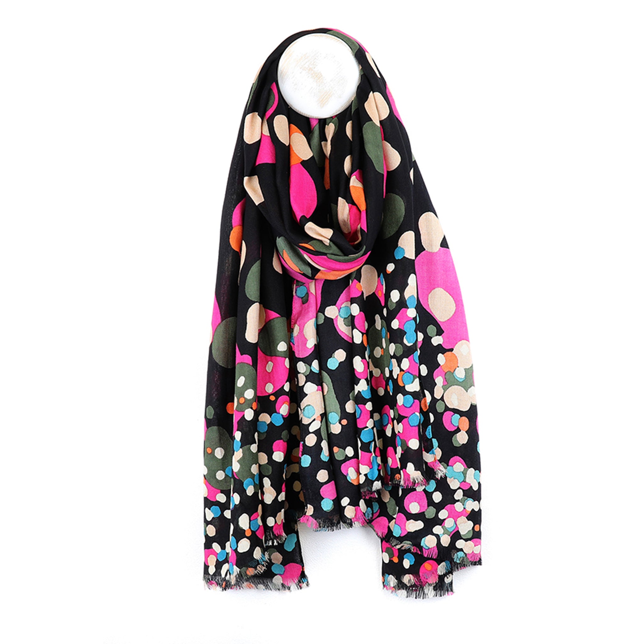 A black scarf with pink, green and blue spots in a gradient size pattern